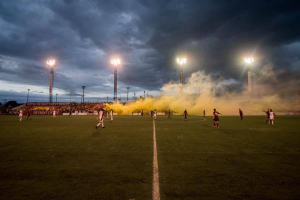 Smoke from supporter smoke bombs roll over the pitch.