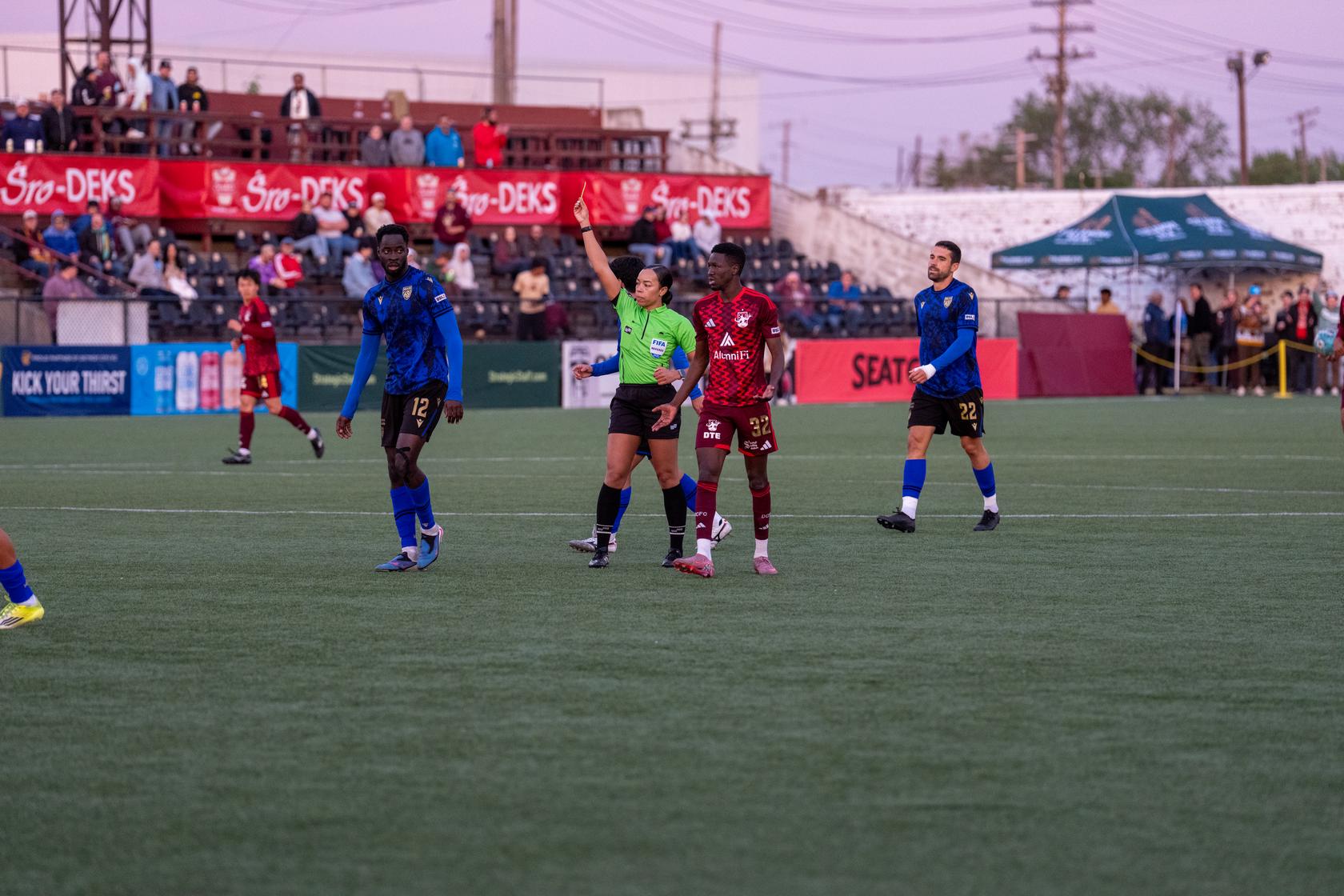 The referee calls one of many yellow cards in the Detroit City FC -Miami FC match