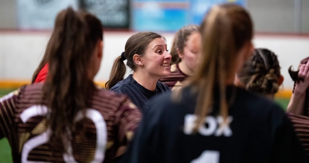 Head Coach Dani Evans smiles while leading her team's pregame meeting.