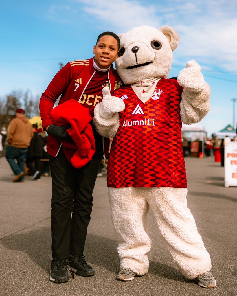 Friendly the Bear, Detroit City FC mascot, greeting fans at a youth soccer event